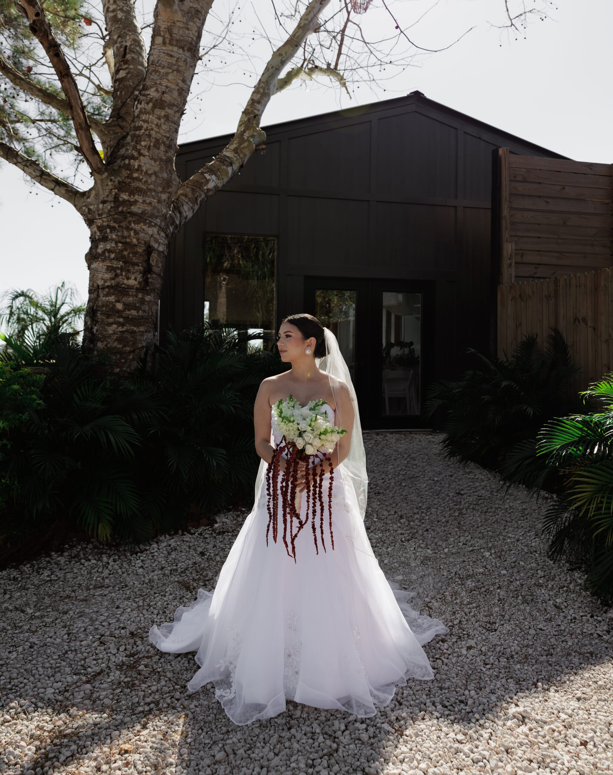 Karla with her bouquet in front of the black barn at The Hill House, Clermont, FL.