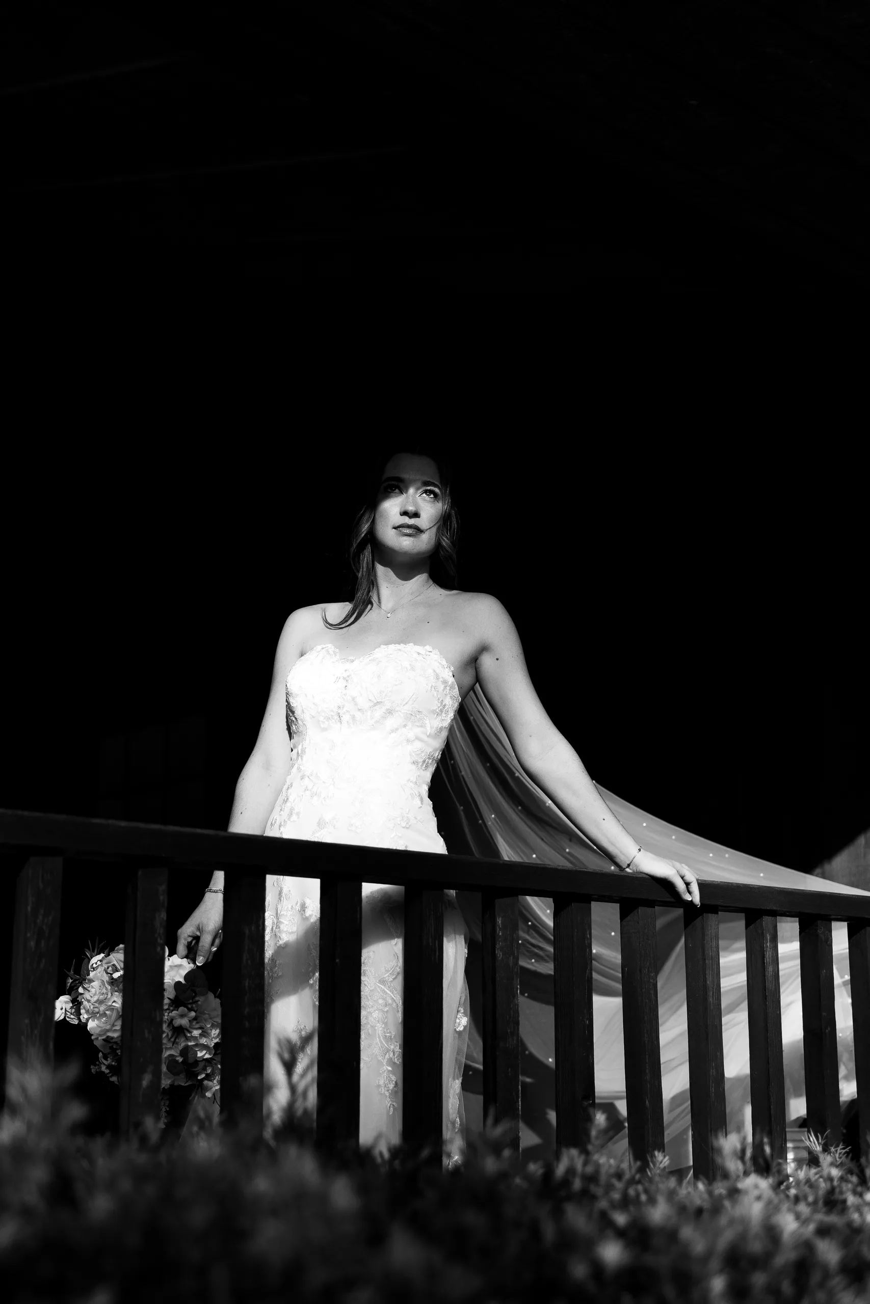 Black-and-white portrait of the bride at the porch railing at Cypress Creek Farmhouse, Orlando FL