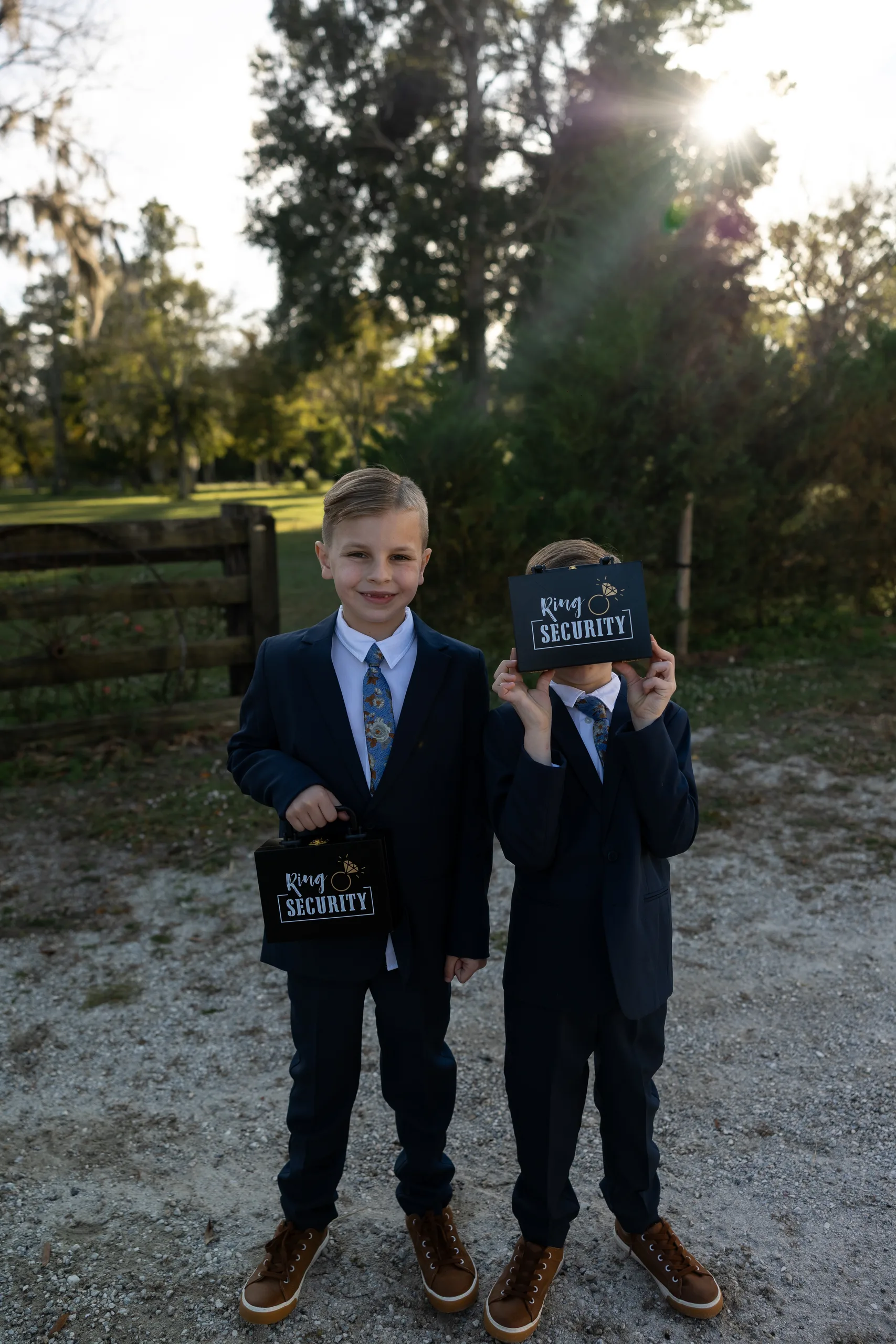 Ring bearers with ring security briefcases by the pasture fence at Cypress Creek Farmhouse, Orlando FL