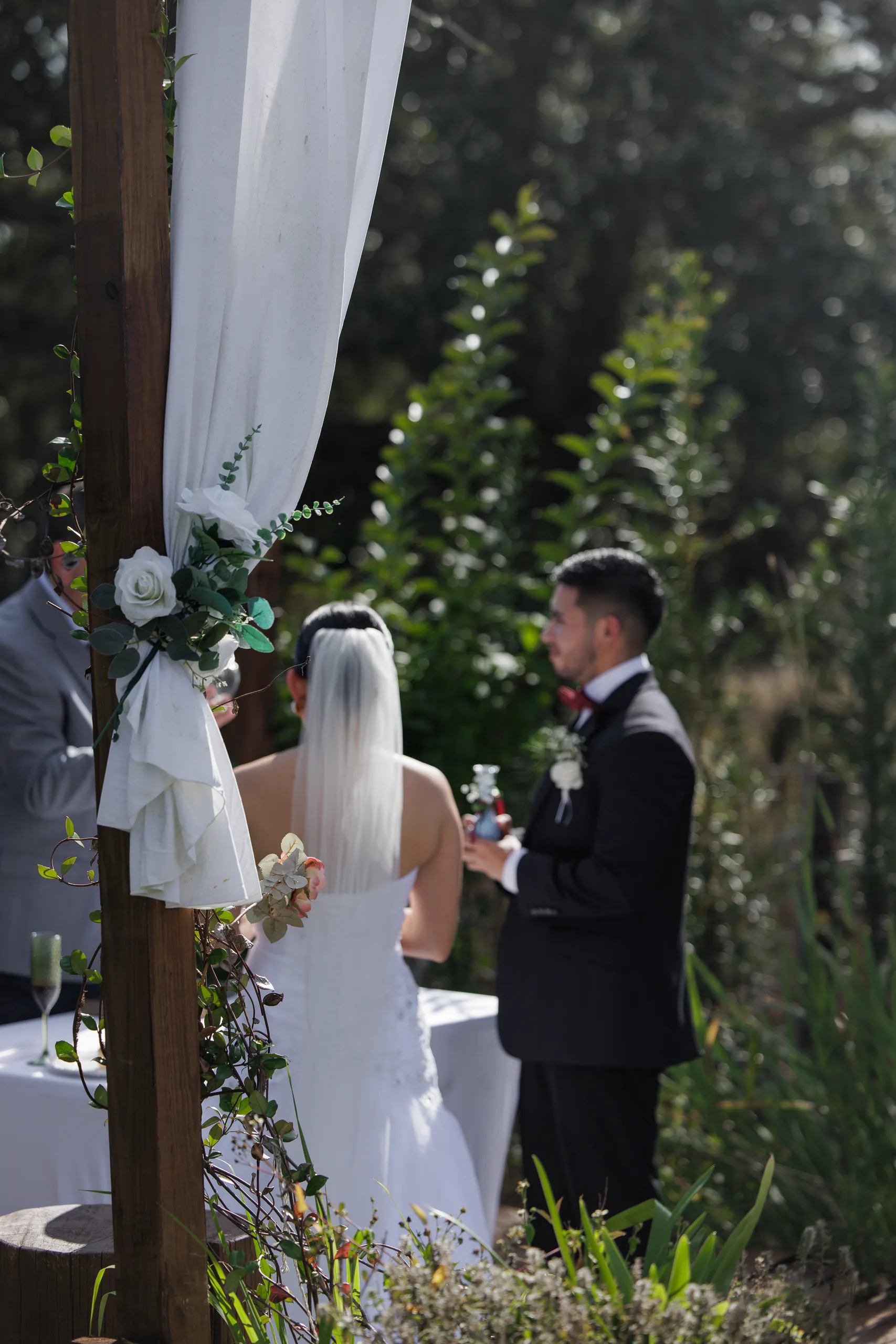 Bride and groom beside the arch florals during the ceremony at The Hill House, Clermont FL