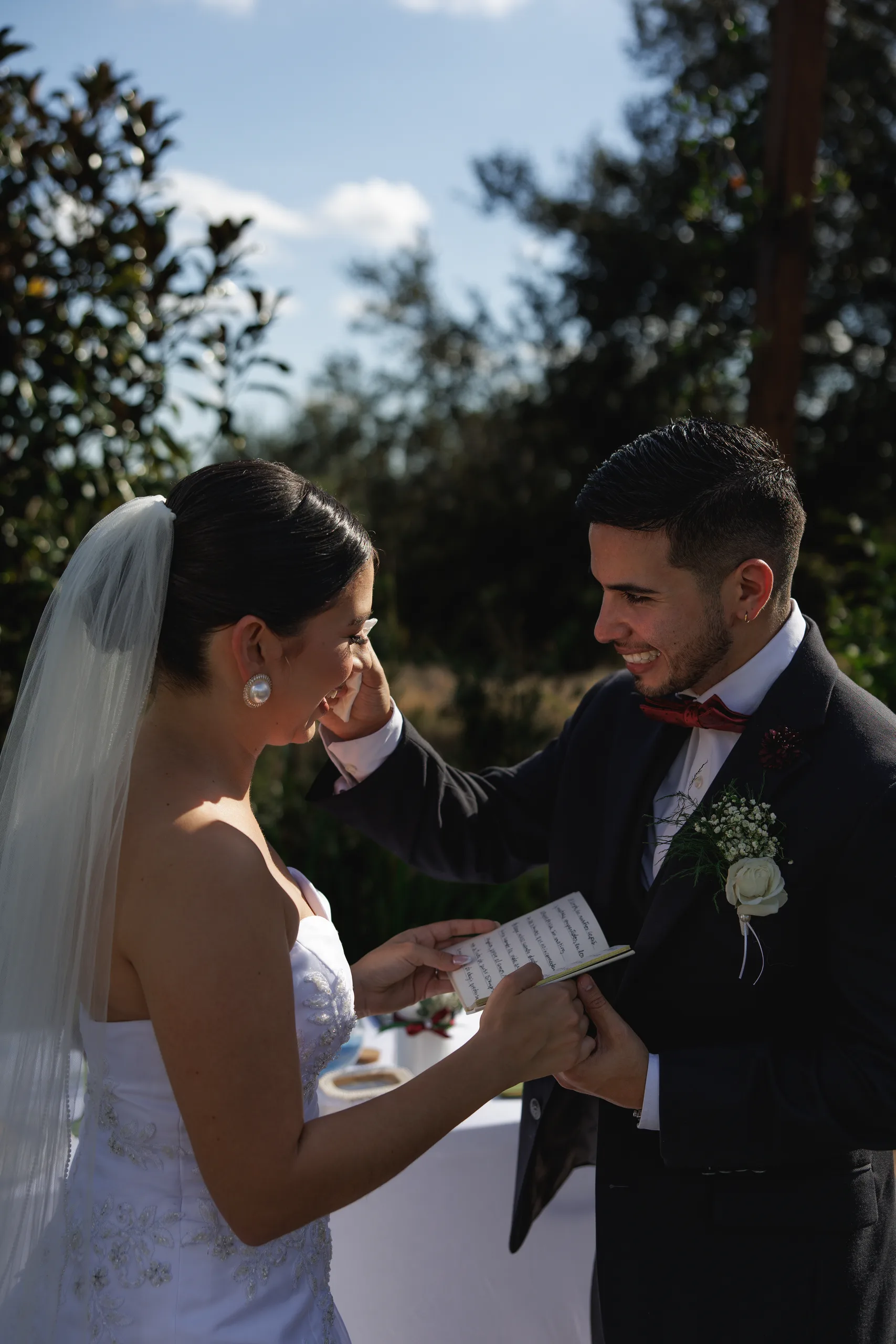 Groom reaching for the bride's cheek as she reads her vows at The Hill House, Clermont FL