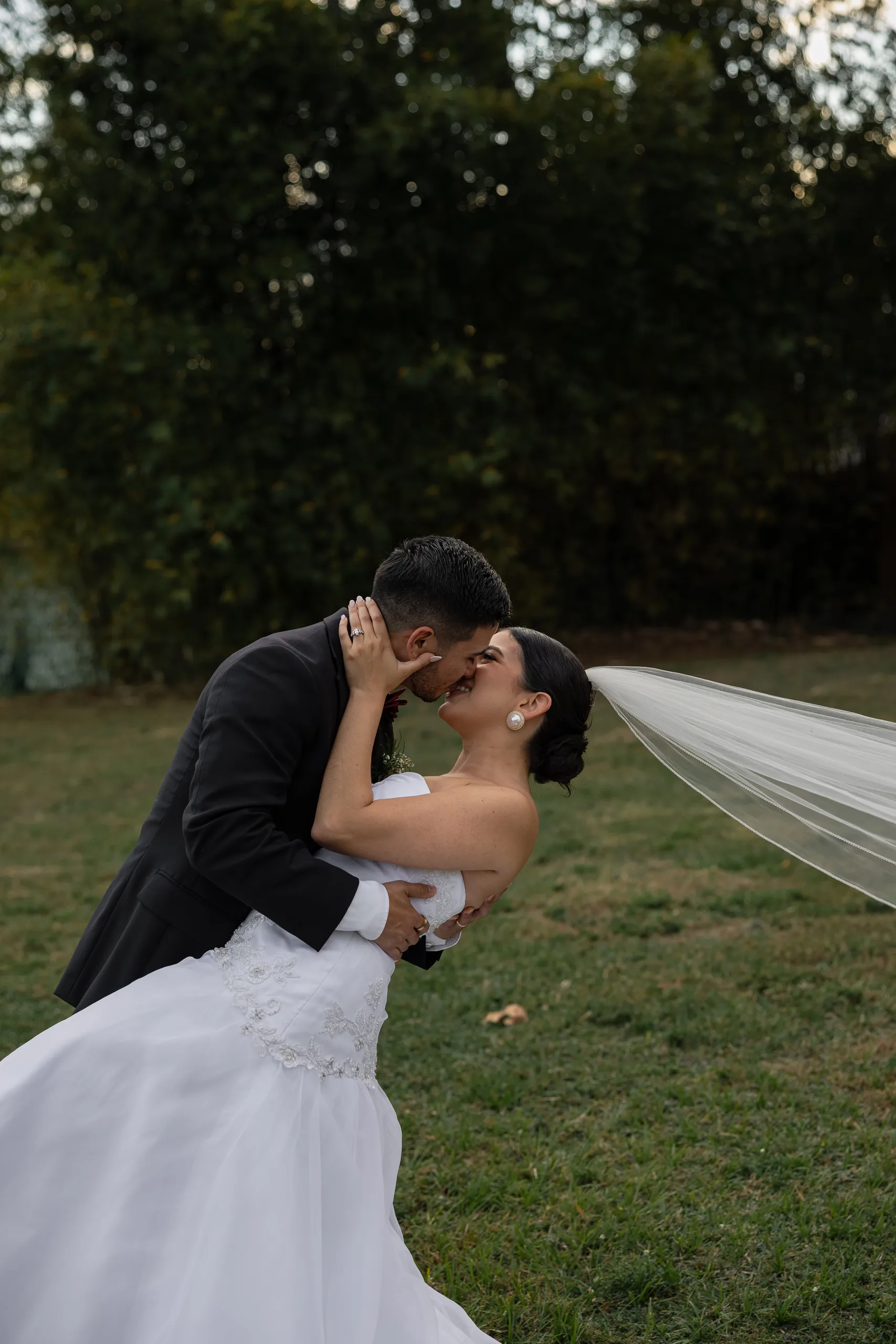 Groom dipping the bride for a kiss on the open lawn at The Hill House, Clermont FL