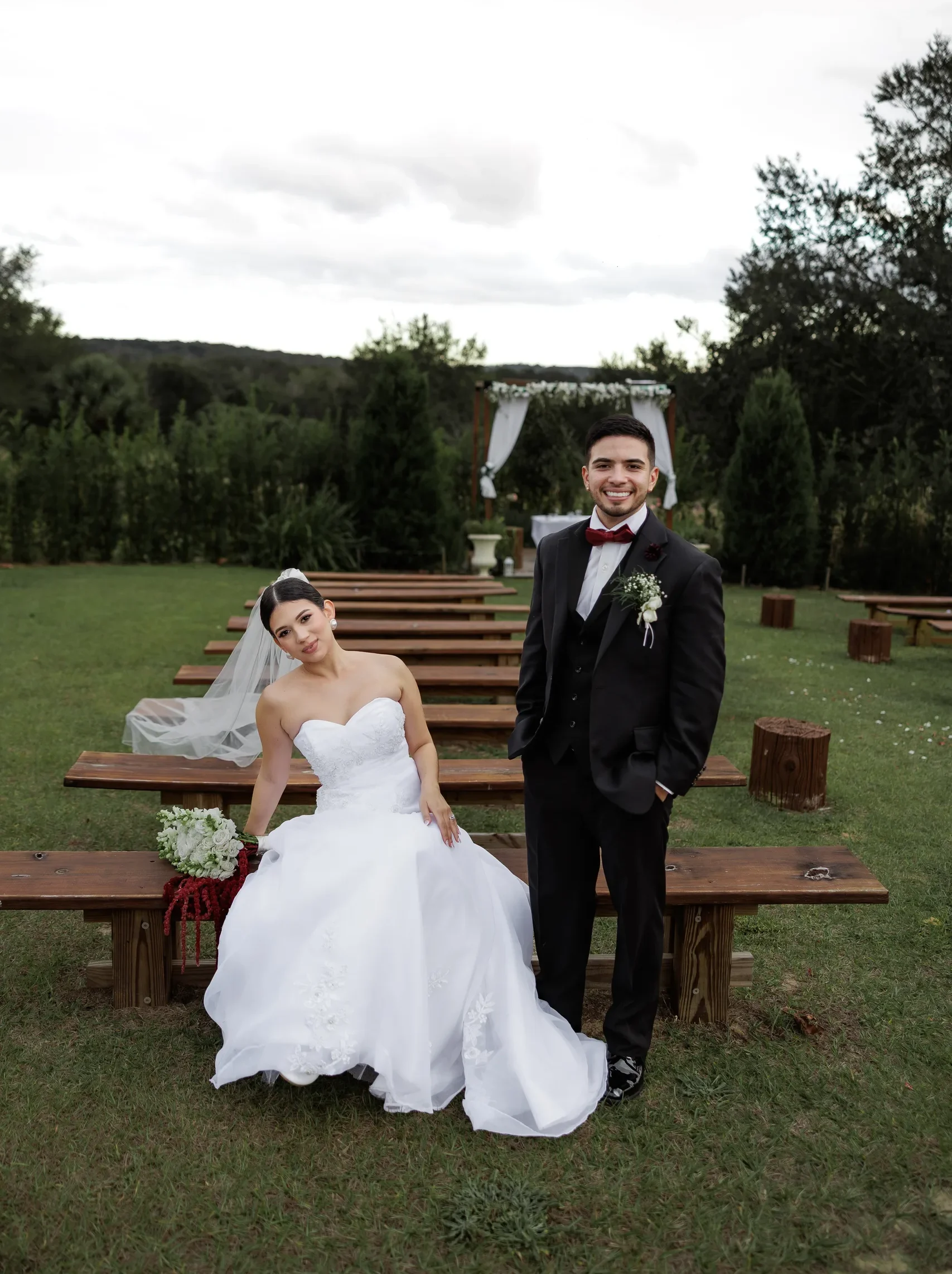 Newlyweds seated on the wooden ceremony benches at The Hill House, Clermont FL