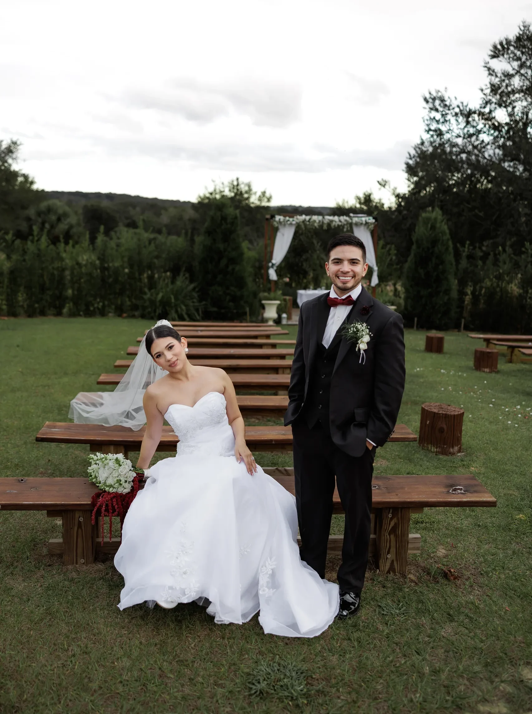Newlyweds seated on the wooden ceremony benches at The Hill House, Clermont FL