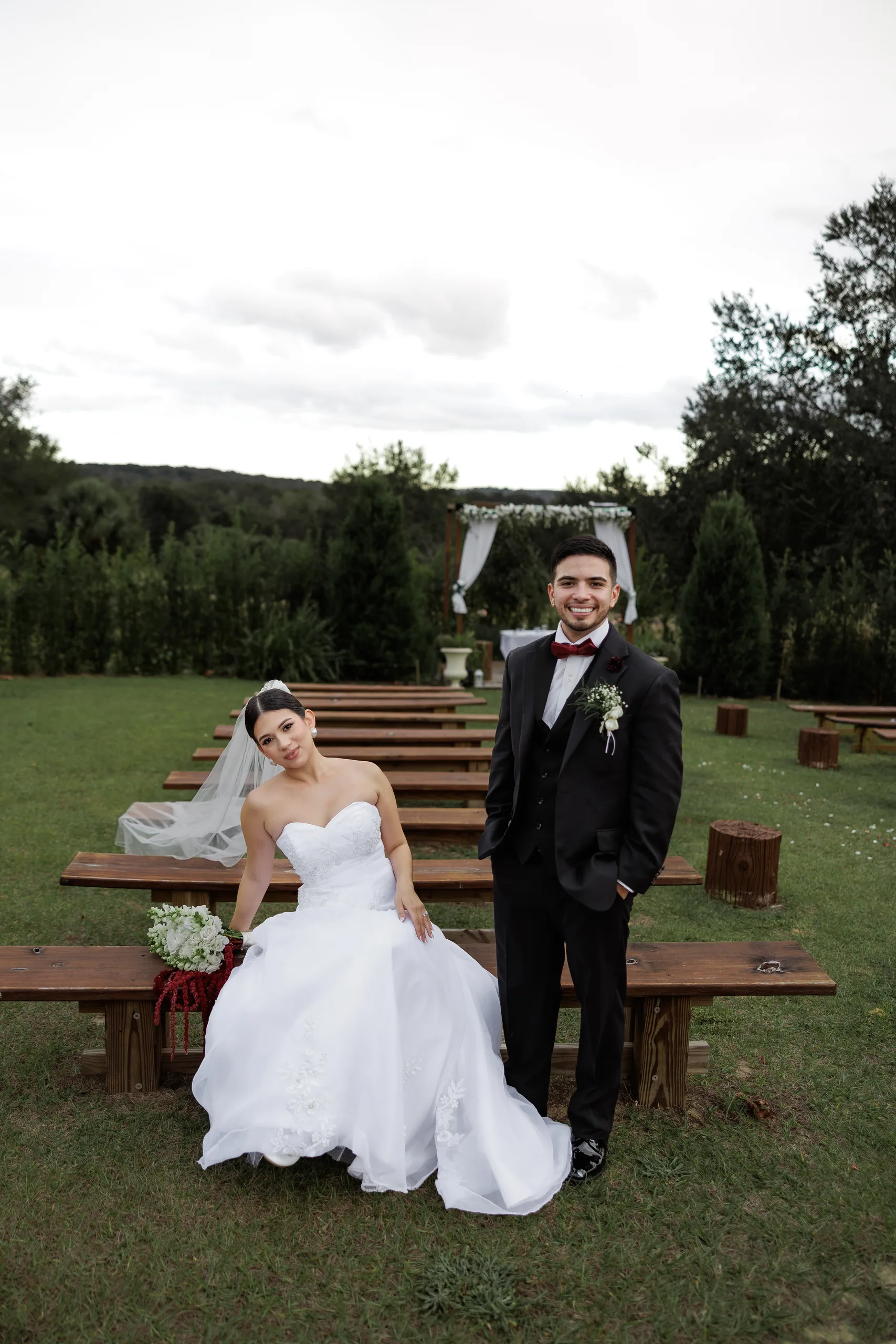 Newlyweds seated on the wooden ceremony benches at The Hill House, Clermont FL