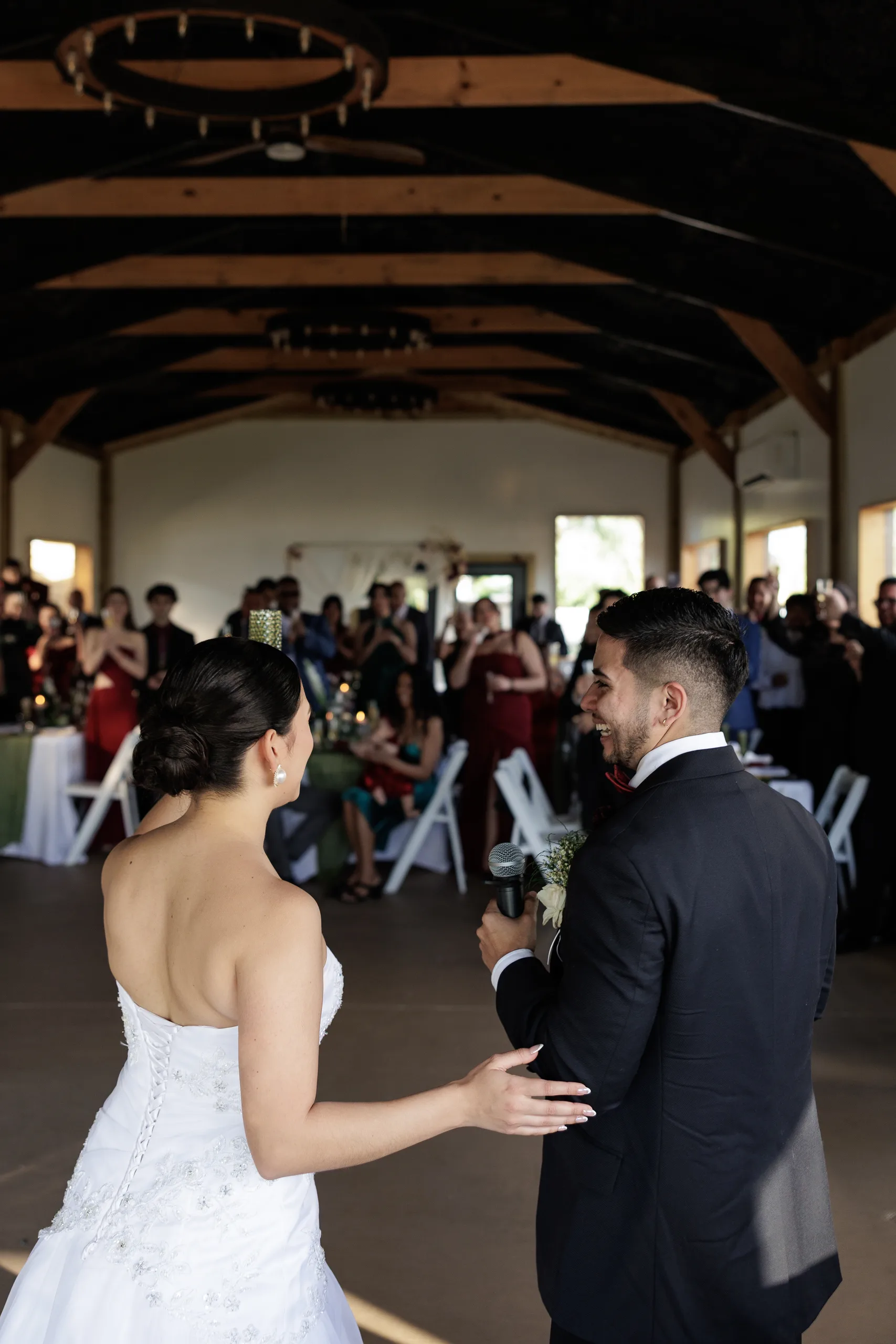 Bride and groom sharing a toast inside the timber-beam reception barn at The Hill House, Clermont FL