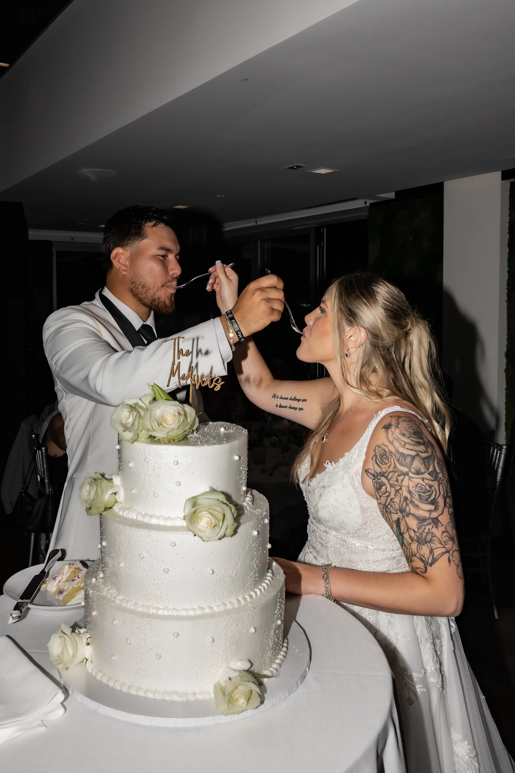 Bride and groom share the first bite of their three-tier cake topped with 'The Medinas' at The J House Greenwich, Greenwich CT