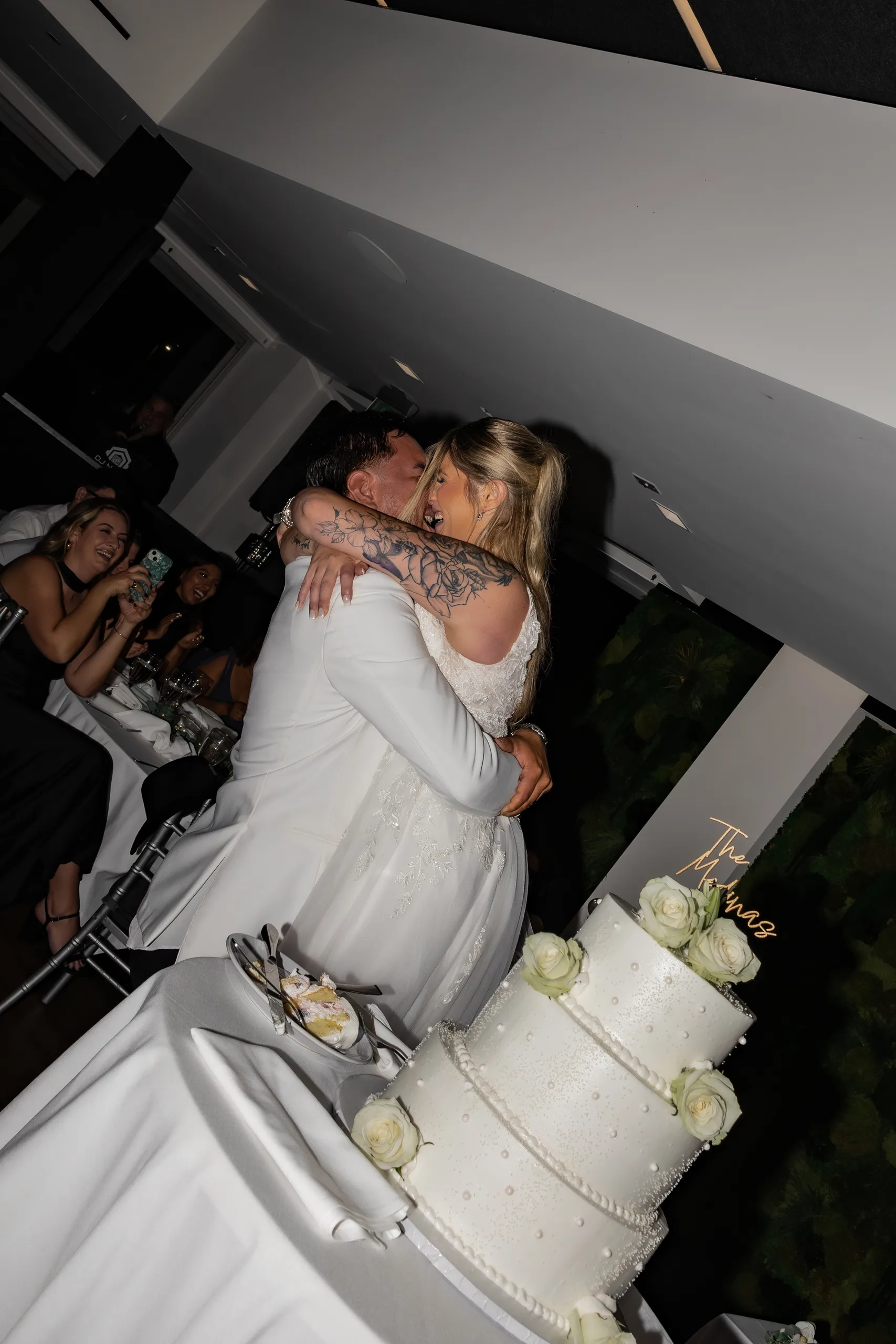 Newlyweds embracing beside the cake table at The J House Greenwich, Greenwich CT