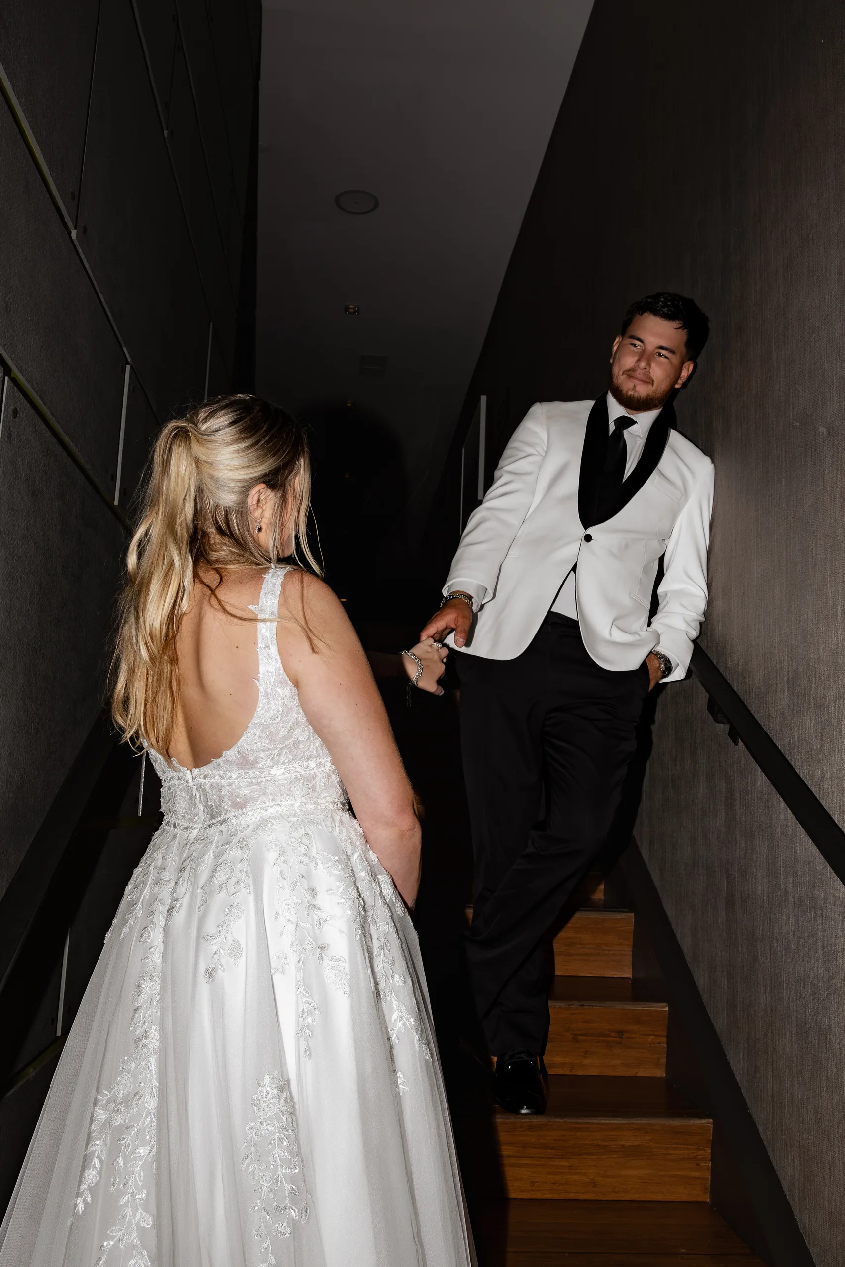 Groom leading the bride up the dark paneled staircase at The J House Greenwich, Greenwich CT