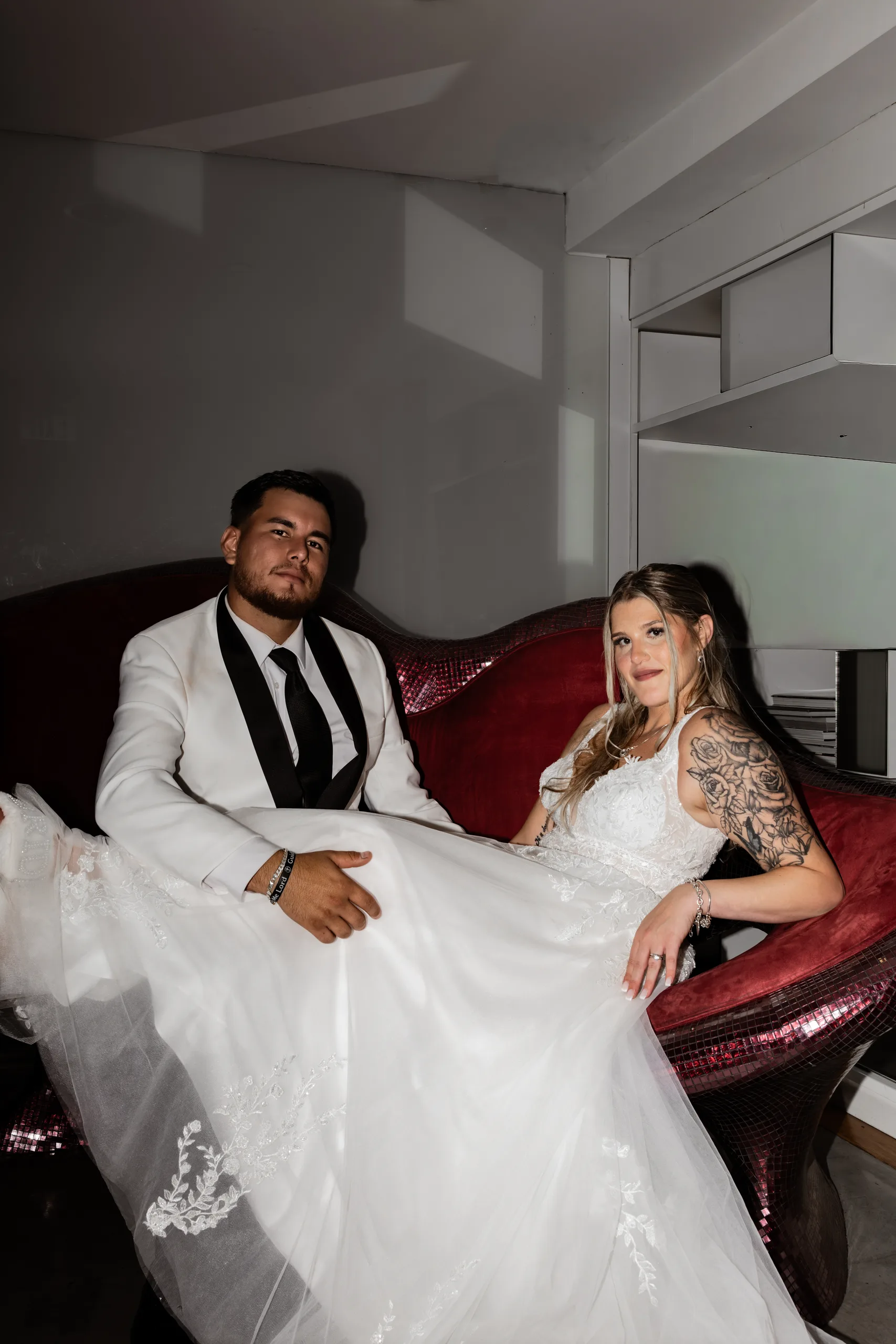 Bride and groom on the red velvet lounge at The J House Greenwich, Greenwich CT