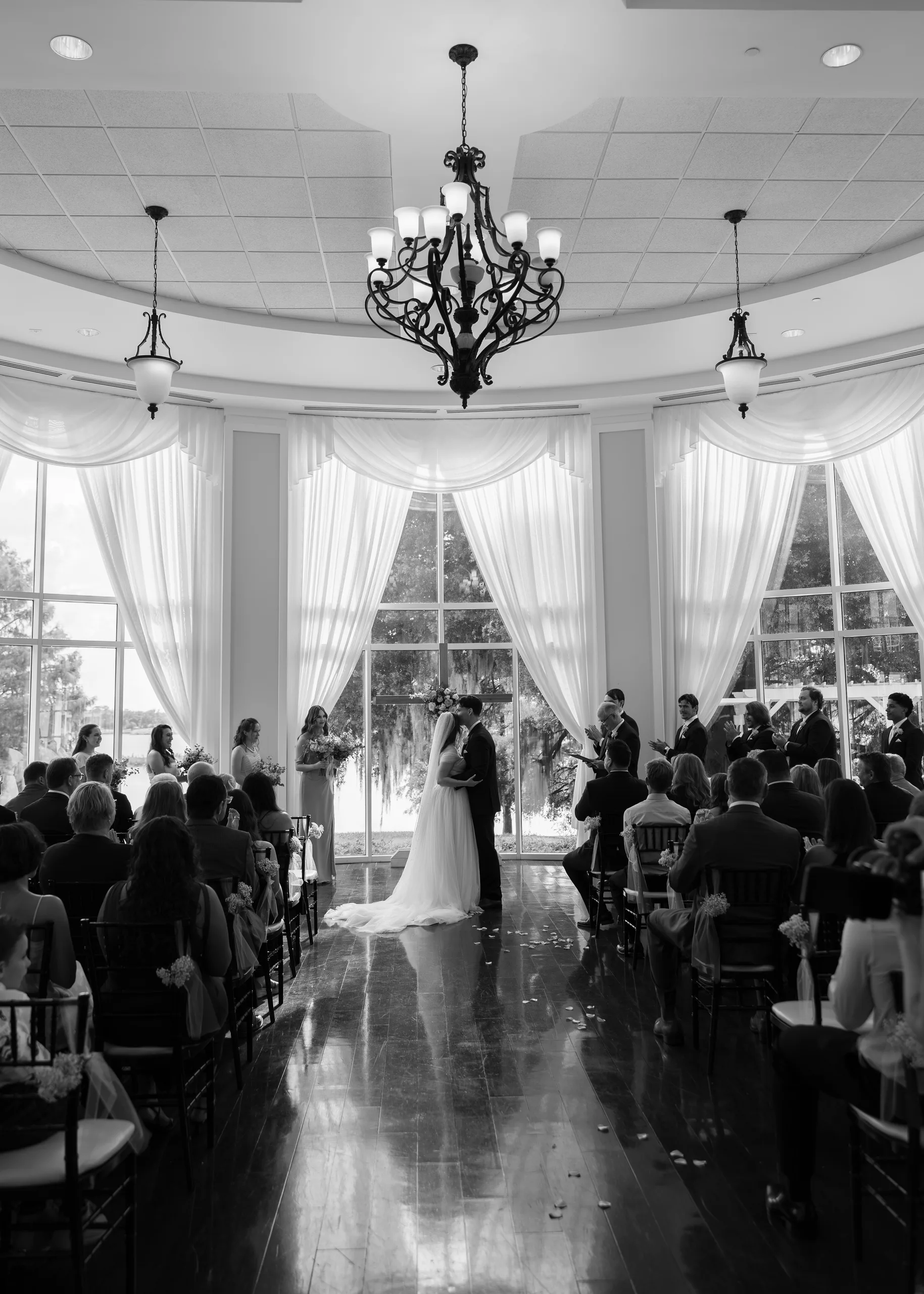 Wide view of the ceremony room as the couple kisses at the altar at Lake Mary Events Center