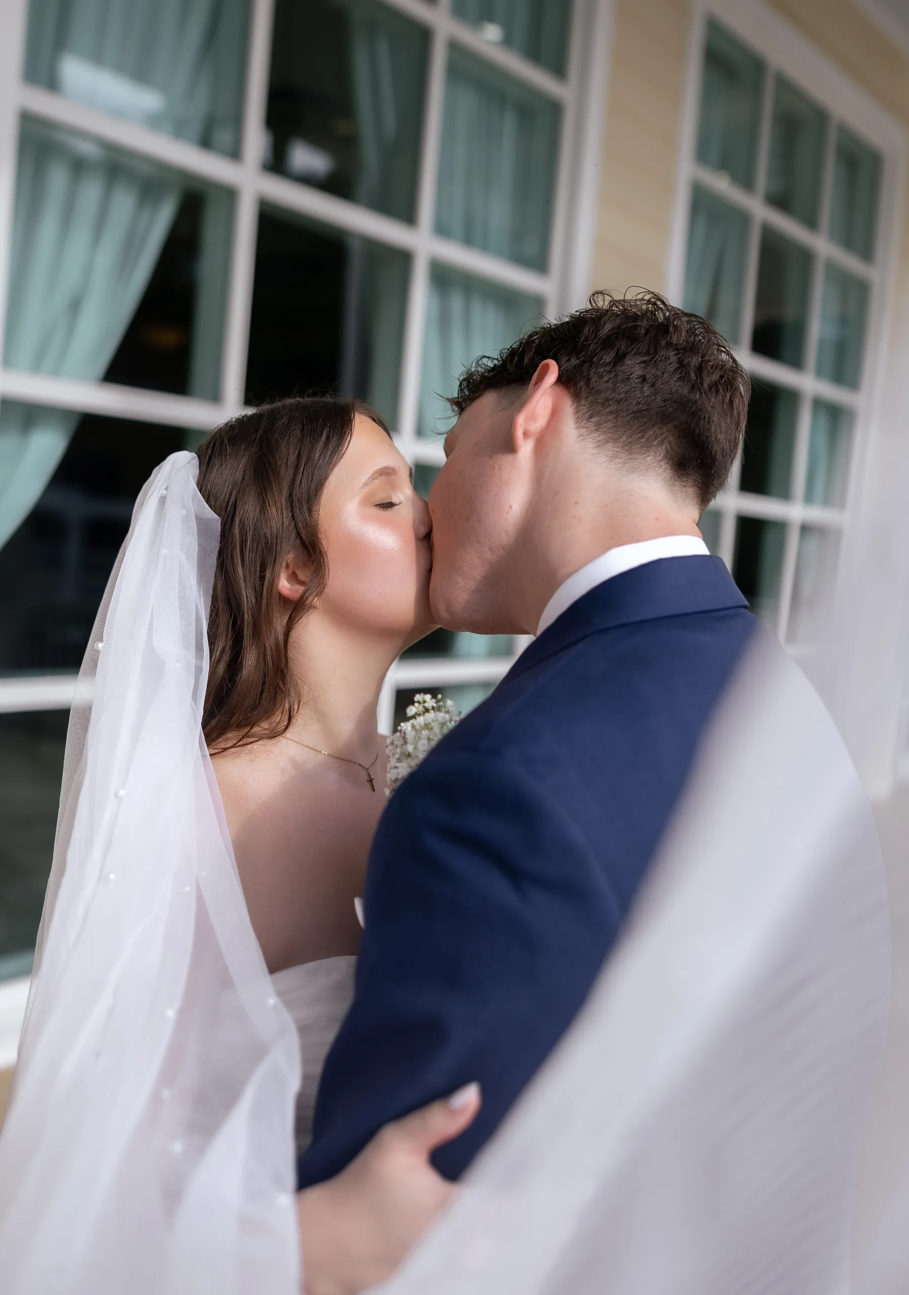 Bride and groom kissing on the porch at Lake Mary Events Center