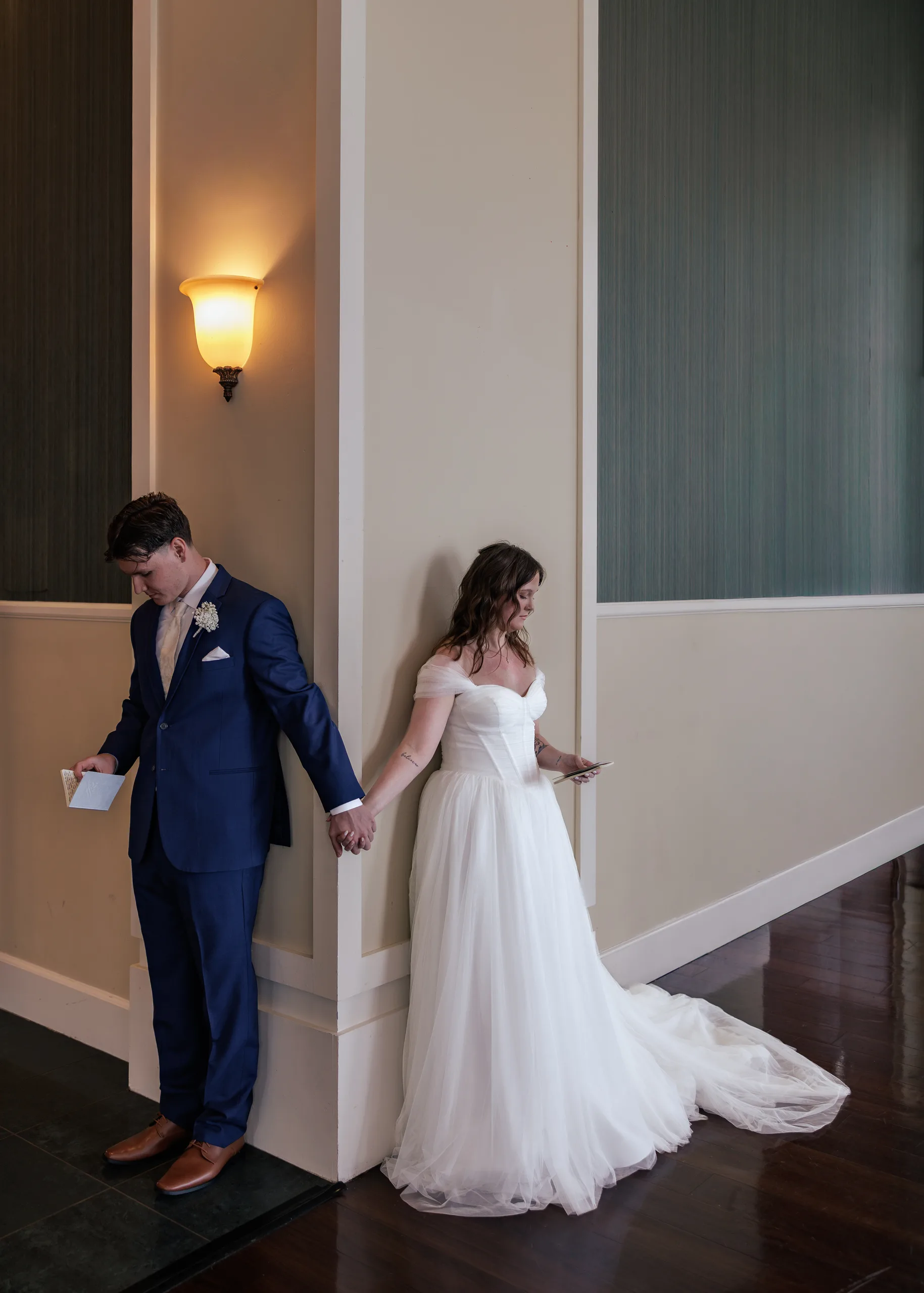 Bride and groom reading letters to each other before their first look at Lake Mary Events Center